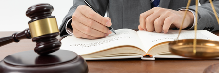 ed244550-cea4-4b0d-bffa-4aae6d3cb184-closeup-shot-person-writing-book-with-gavel-table(1).png
